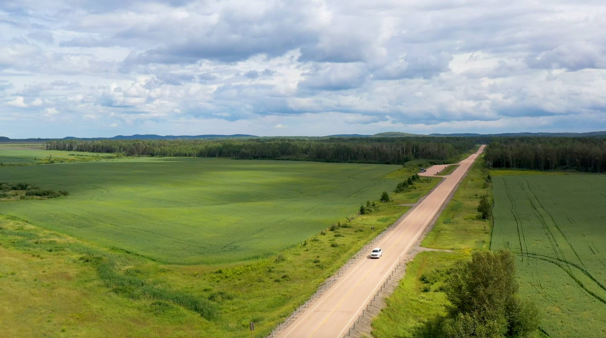 A long road surrounded by two fields